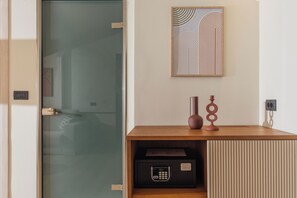Una habitación moderna con un escritorio de madera, una caja fuerte y una obra de arte abstracta enmarcada en la pared.