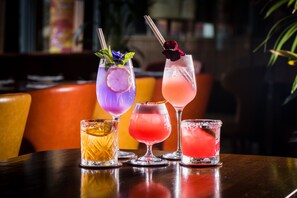 Four different cocktails on a table with a blurred background.