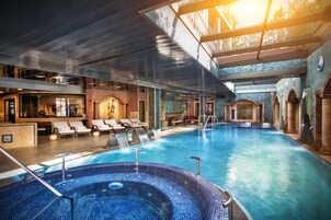 Una piscina cubierta, una piscina al aire libre, tumbonas