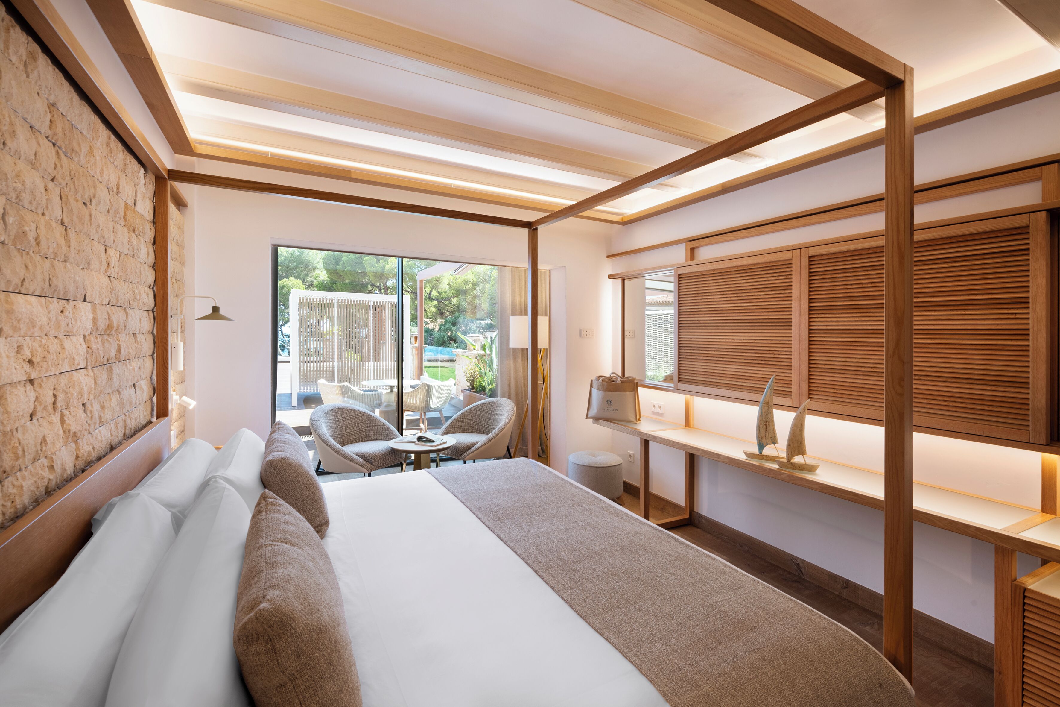 Una habitación de hotel moderna con una cama grande, un escritorio y una zona de estar con sillas.
