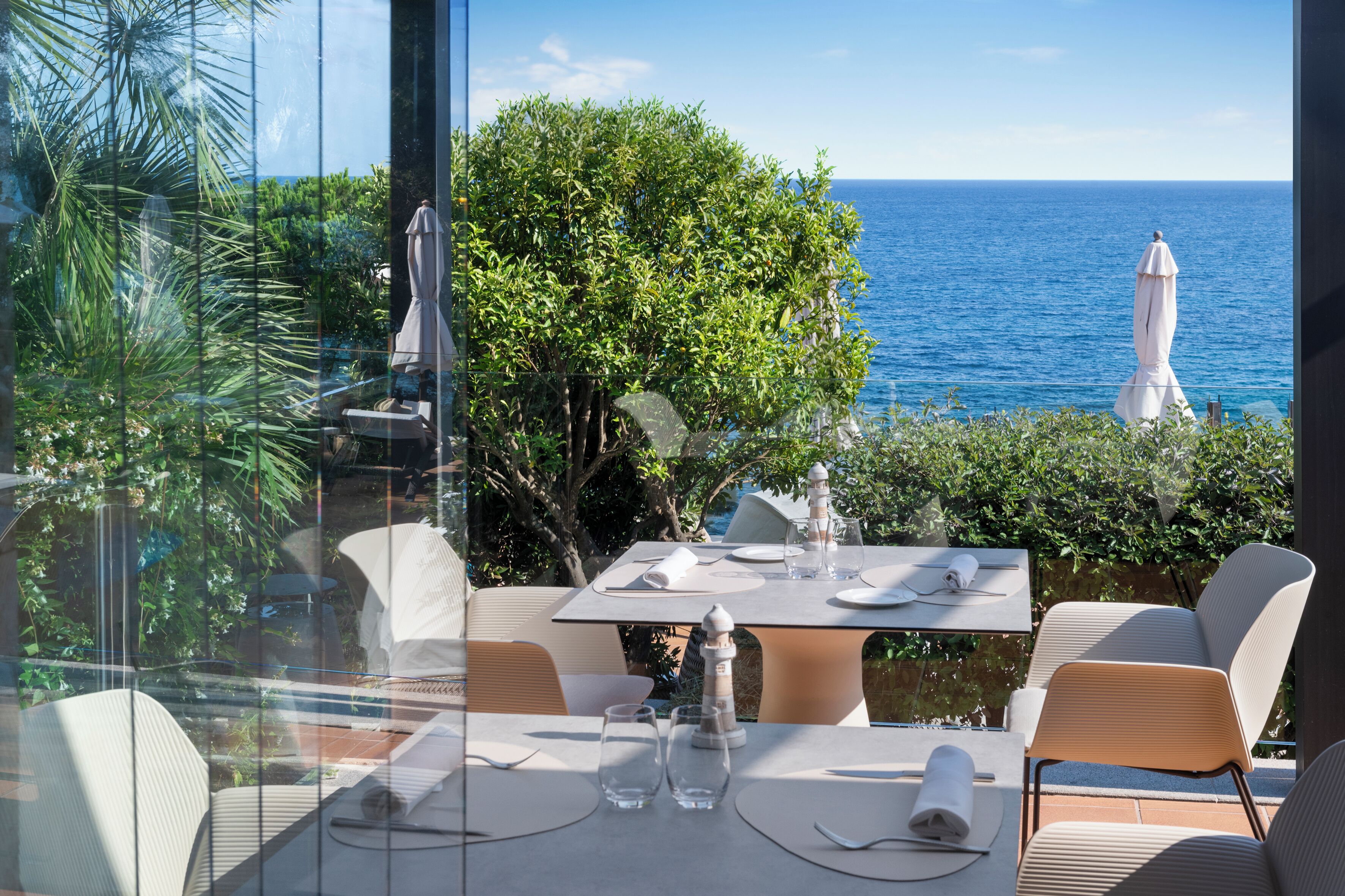 A dining area with a table set for two, overlooking the sea.