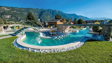 Relax by the pool surrounded by lush greenery and a majestic mountain range.