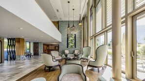 En rummelig lobby med høje lofter, store vinduer og moderne møbler.
