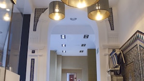 Una imponente escalera con barandillas ornamentadas y un candelabro.