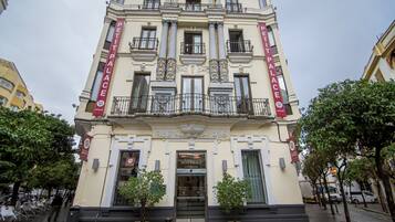Un edificio histórico con una entrada destacada, columnas y balcones.