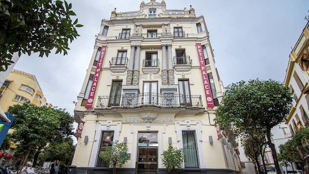 Un edificio histórico con una entrada imponente, columnas y balcones.