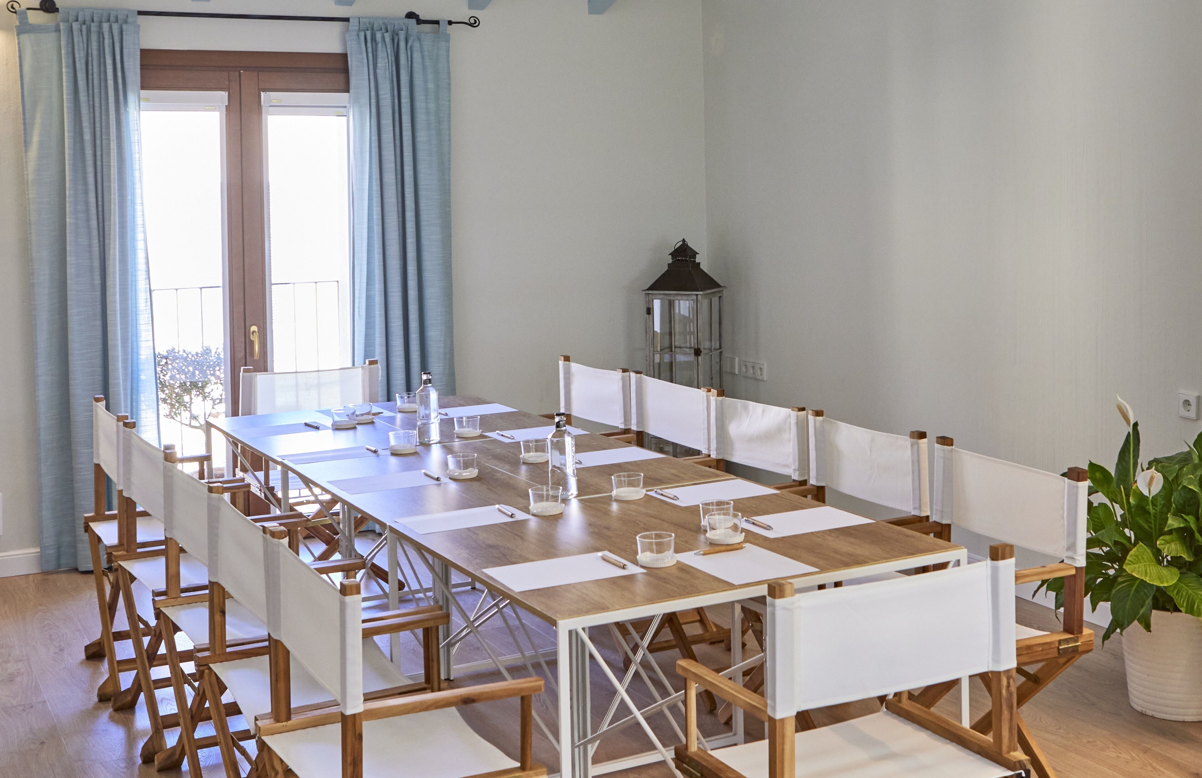 A conference room with a long table, chairs, and a lantern.