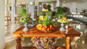 Una mesa de buffet con diversas frutas y plantas en macetas.