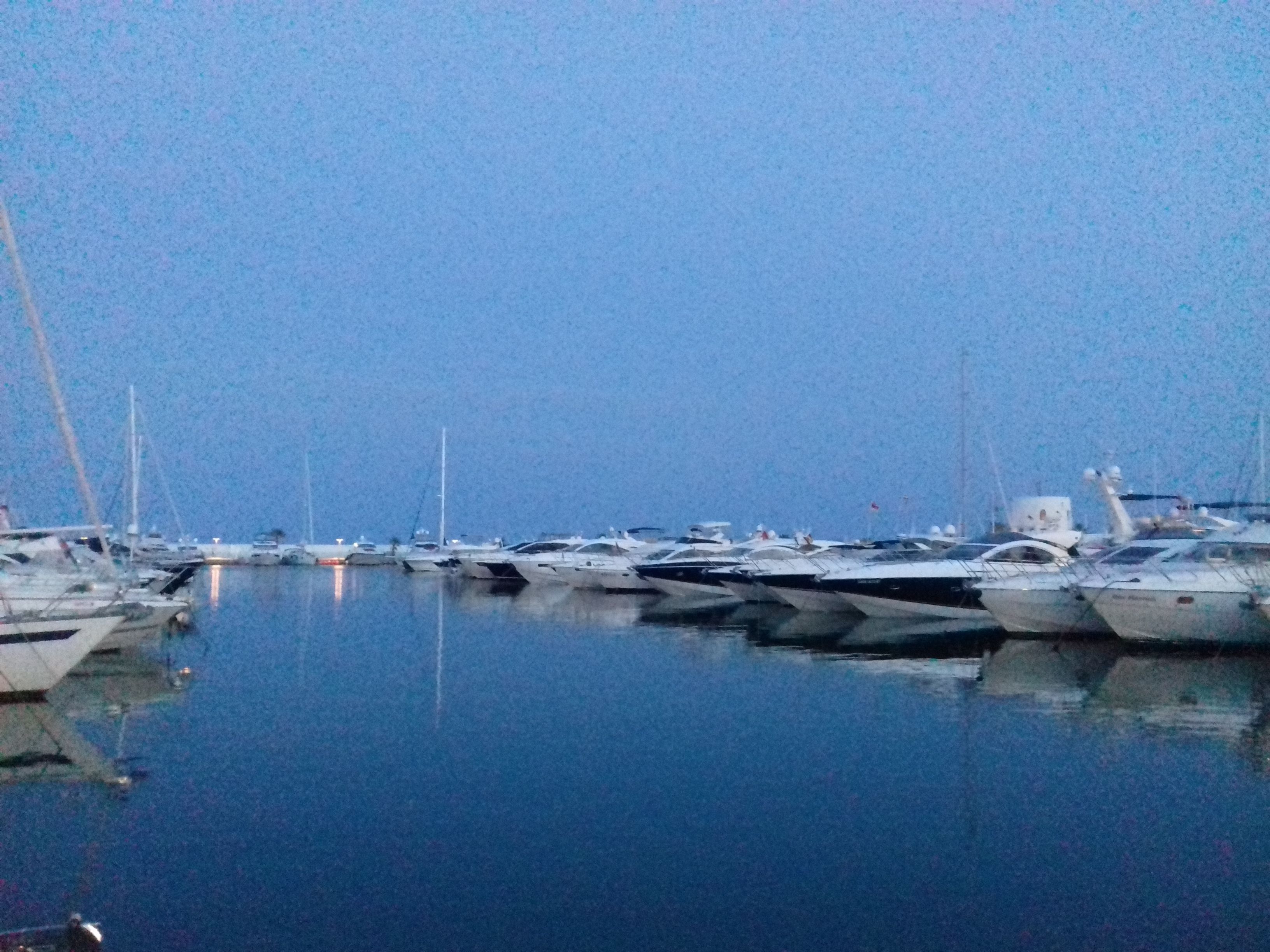 A marina with several boats docked in calm waters.