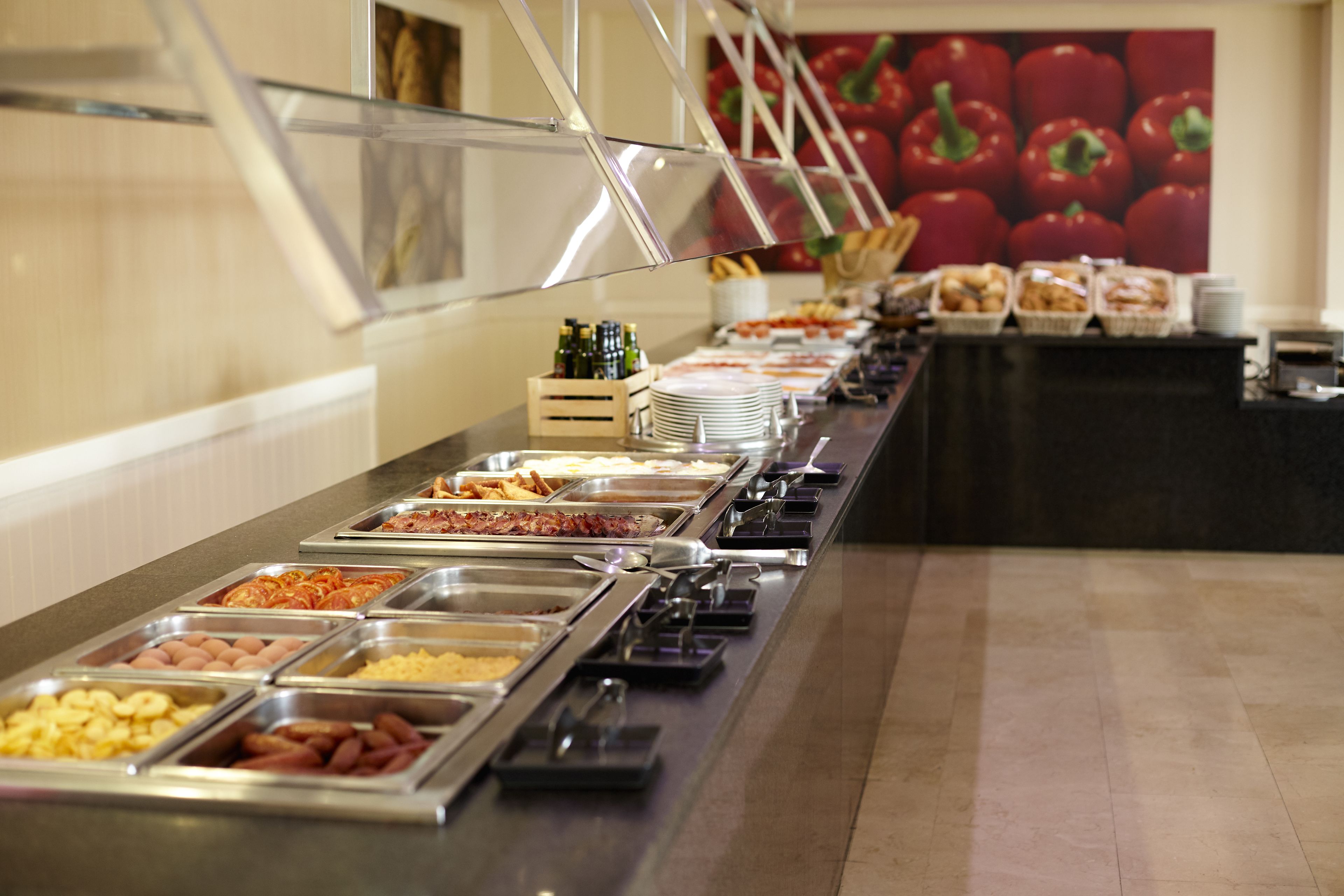 Una barra de buffet con diversos alimentos y salsas.