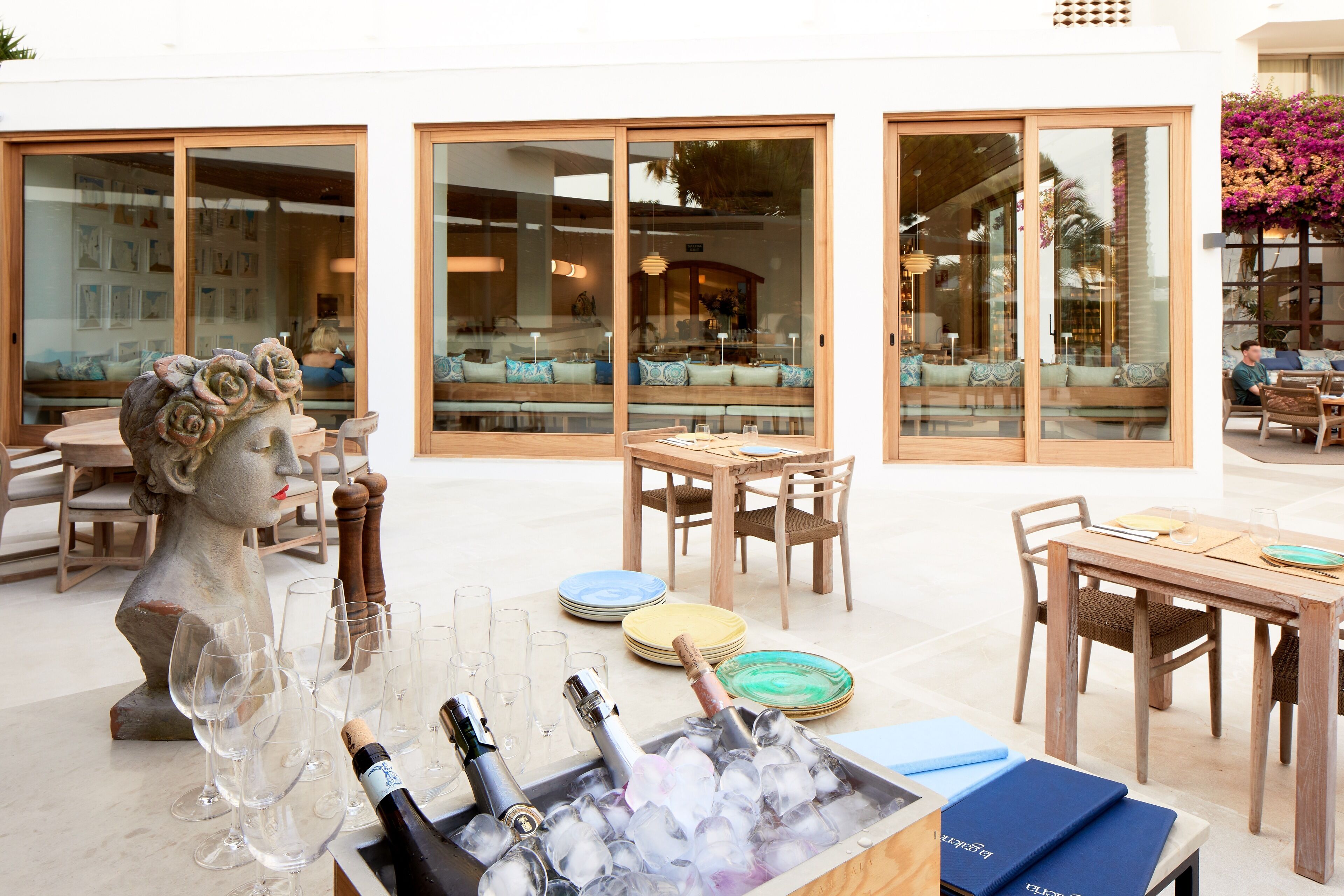 A dining area with tables, chairs, and a statue of a woman.