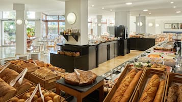 A buffet with various breads and pastries.