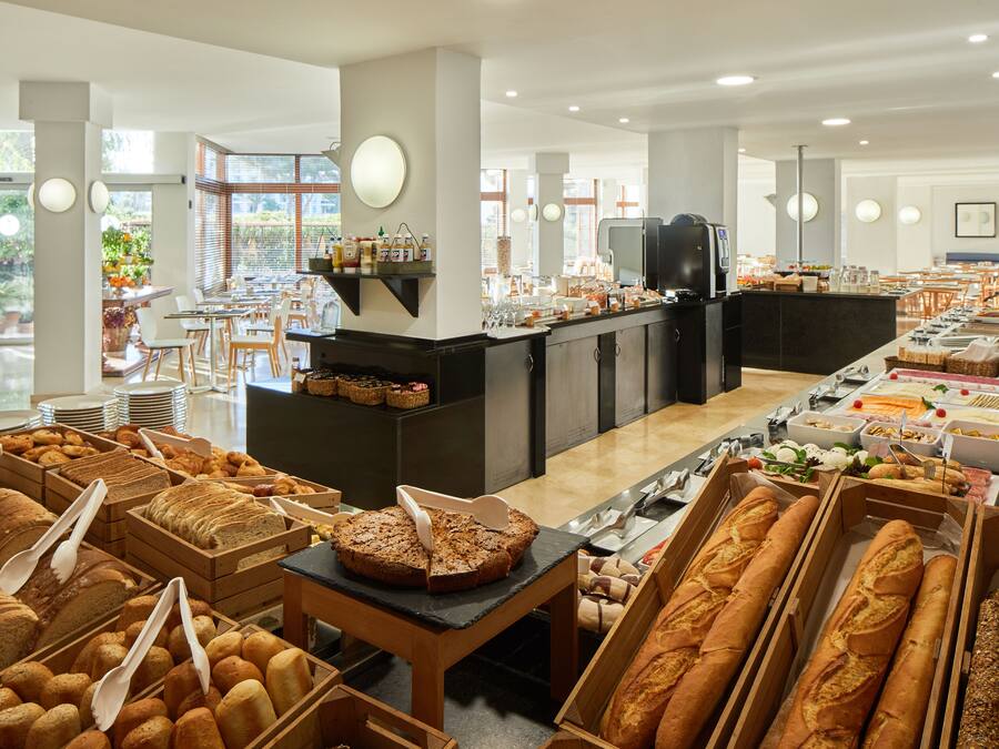 A buffet with various breads and pastries.