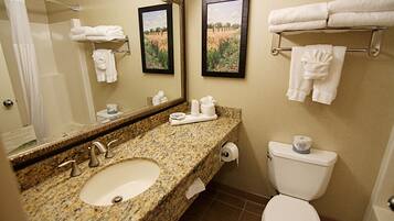 A bathroom with a granite sink, a toilet, and a towel rack.