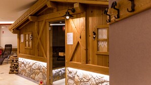 Een houten kamer in blokhutstijl met een fundering van natuursteen, een houten deur en een klein raam.