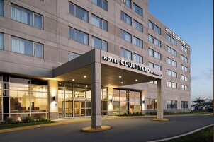 A hotel with a modern facade, large windows, and a covered entrance area.
