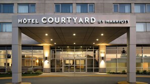 A hotel entrance with a sign reading "HOTEL COURTYARD BY MARRIOTT". - Courtyard by Marriott Montreal Airport (Montreal)