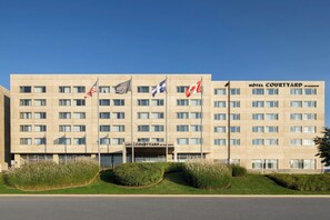 Een hotel met meerdere vlaggen, een plat gevelvlak en een bord waarop staat 