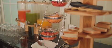 A buffet setup with various food items and drinks.
