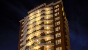 Un hotel de varios pisos con un atrio central, balcones en cada planta y una entrada bien iluminada.