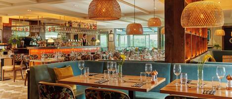 A restaurant with a bar area, booths, and tables set for dining.