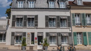 A two-story building with a balcony on the second floor, a door with a number, and a bicycle parked outside.