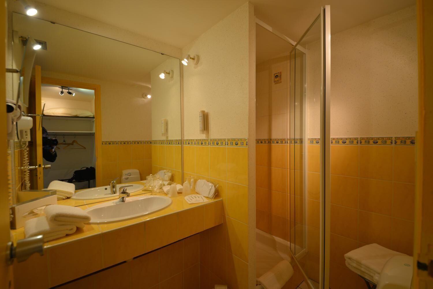 A bathroom with two sinks, a mirror, a shower, and a towel rack.