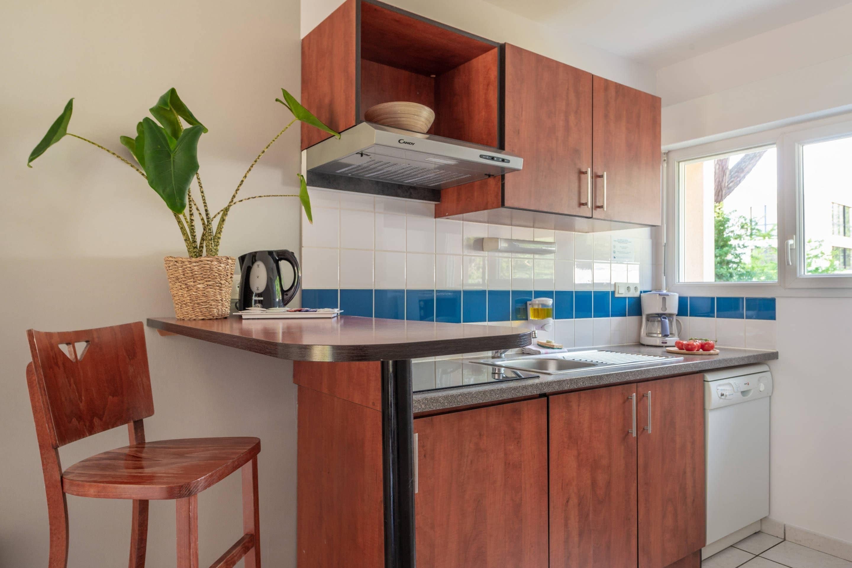 A kitchen with wooden cabinets, a built-in stove, a sink, and a window.