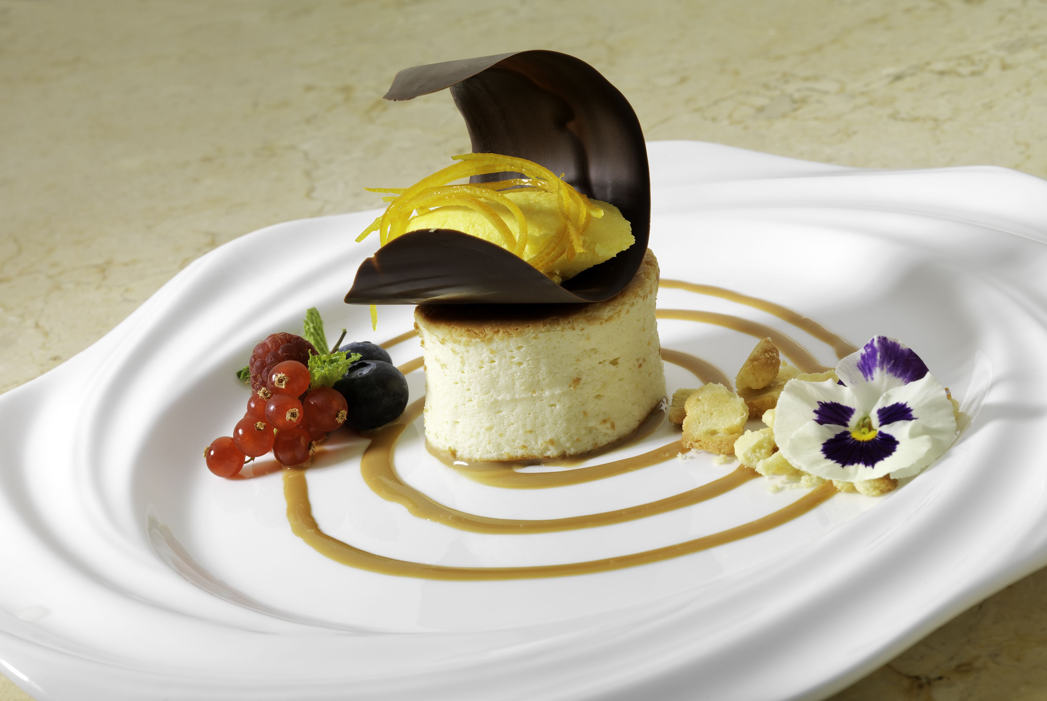 En dessert på en vit tallrik, serverad med karamellsås och garnering.