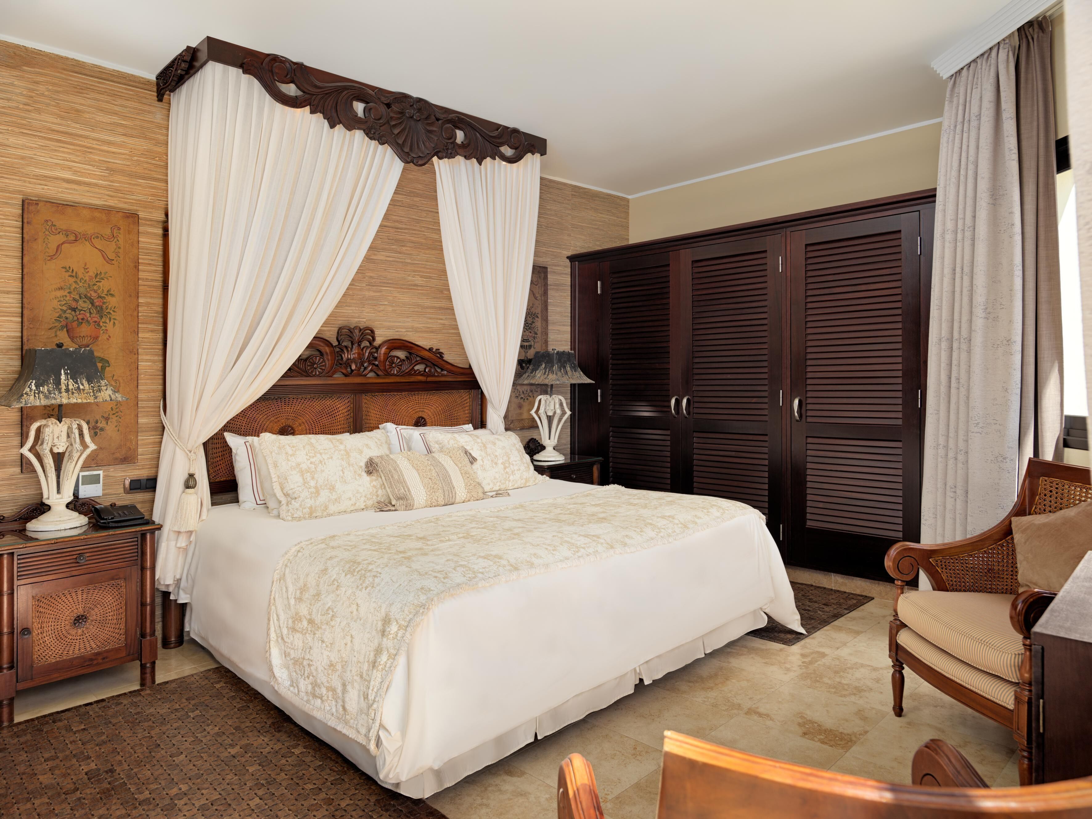 Um quarto espaçoso com uma cama grande, um guarda-roupa de madeira, uma mesa de cabeceira e uma cadeira.