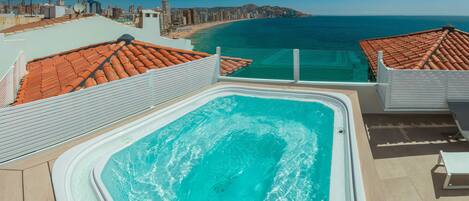 Una piscina en la azotea con vistas a la playa y al paisaje urbano.