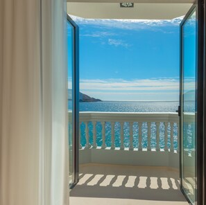 Un balcón con vista despejada al mar y una montaña distante.