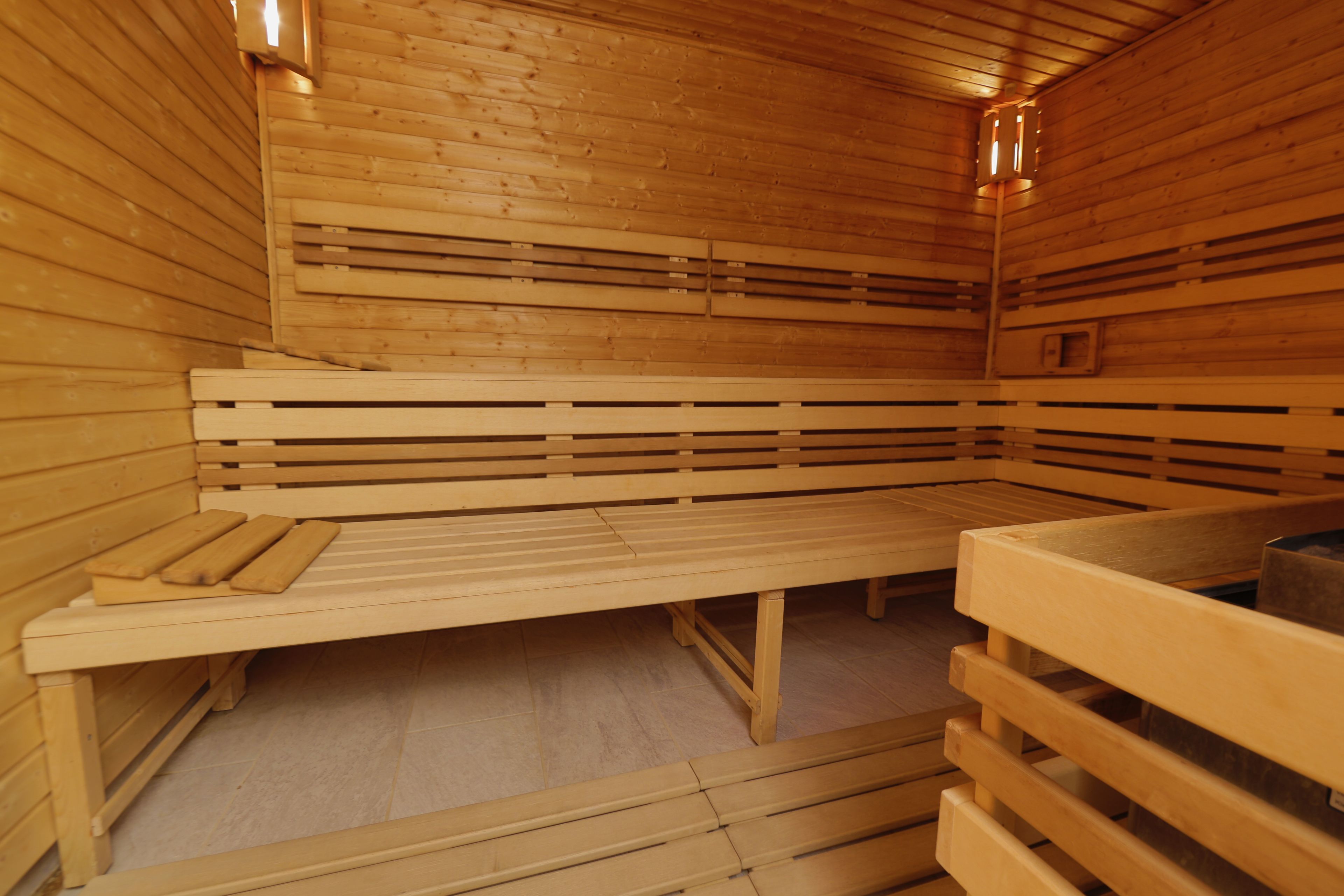 A sauna with wooden benches and benches, a bench with a towel, and a bench with a towel.