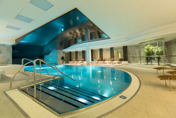 Una piscina cubierta, tumbonas