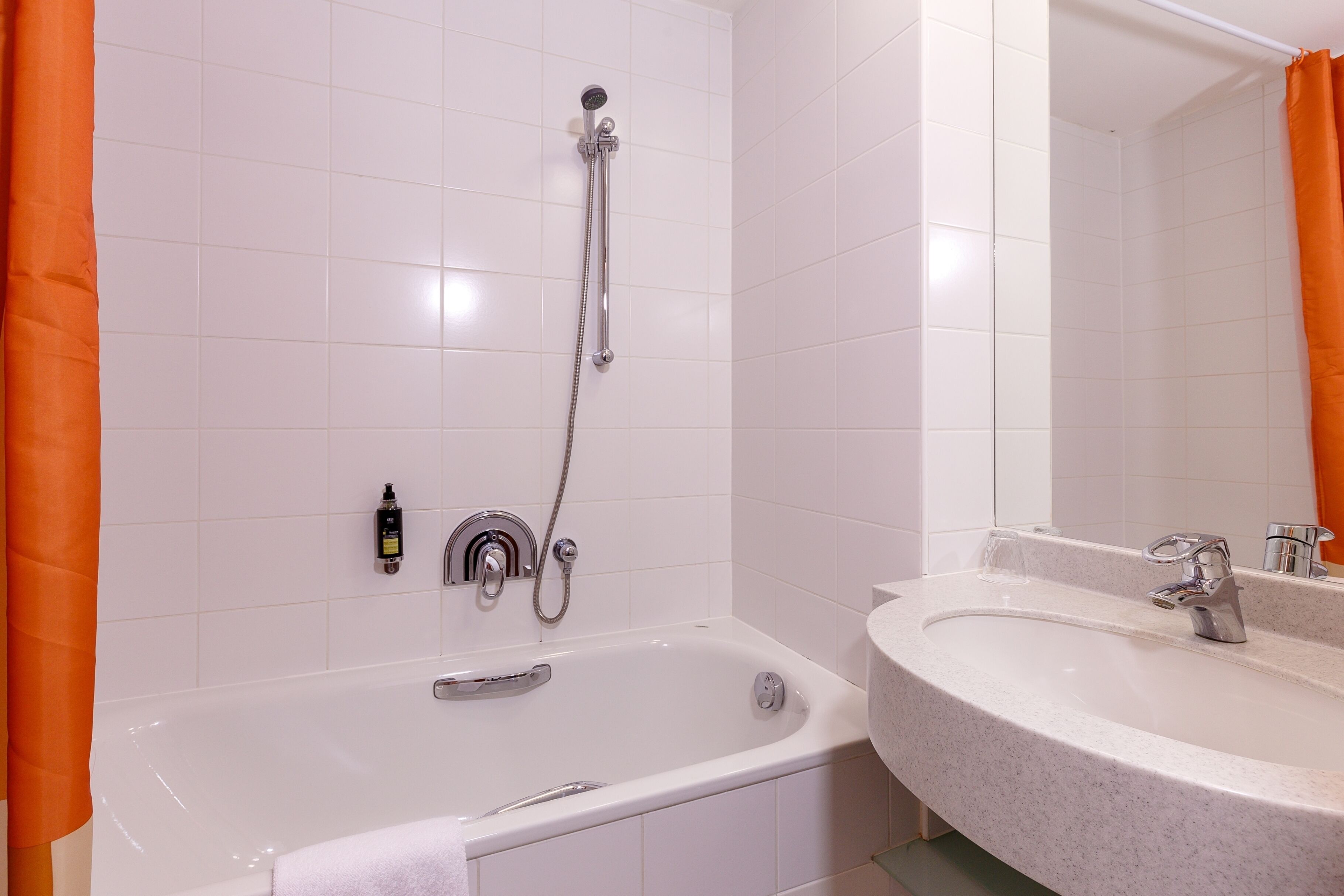 Un baño con bañera, ducha y lavabo con espejo.