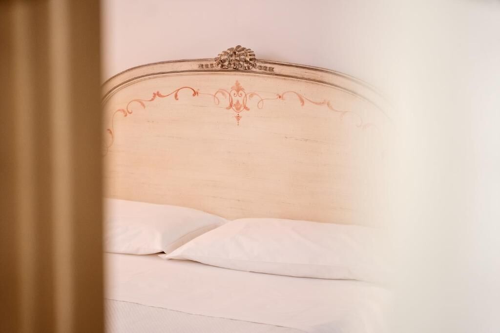A bed with a wooden headboard and white pillows.