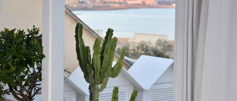 Un balcone con vista sul mare e sugli edifici sullo sfondo.