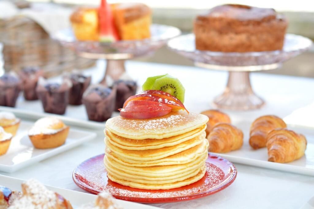 Un bufé de postres con panqueques, pastelería y pastel.