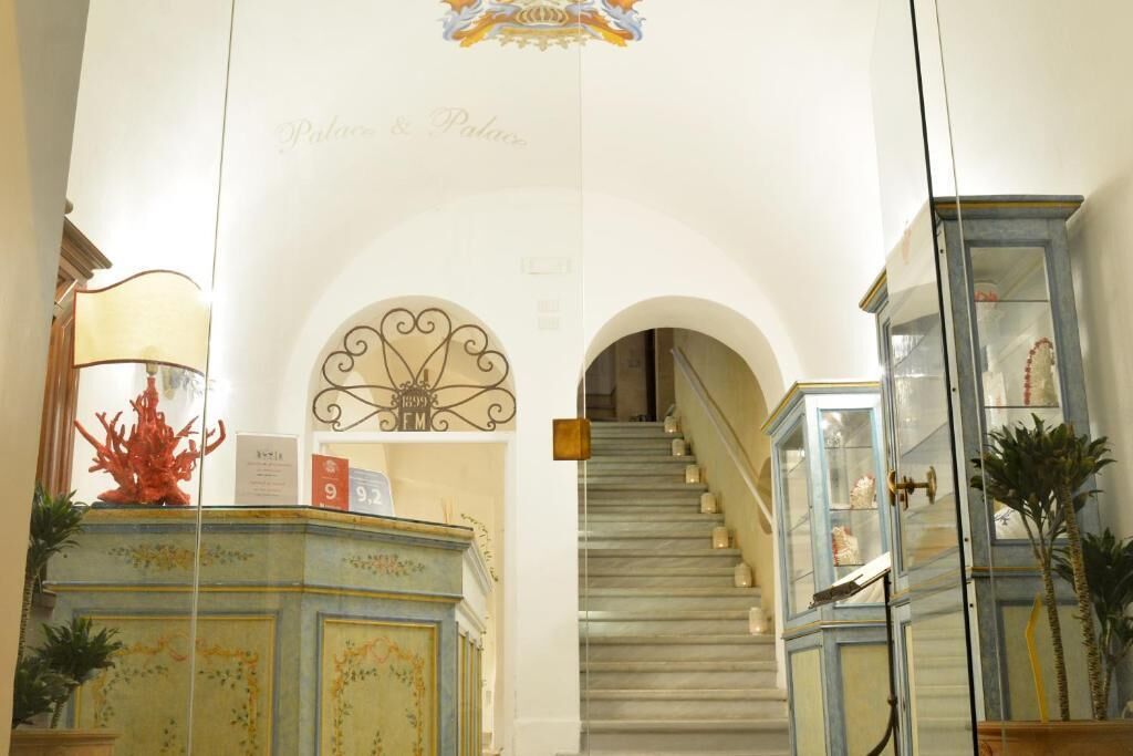 A grand staircase leading to an upper floor, flanked by ornate cabinets and a decorative ceiling.