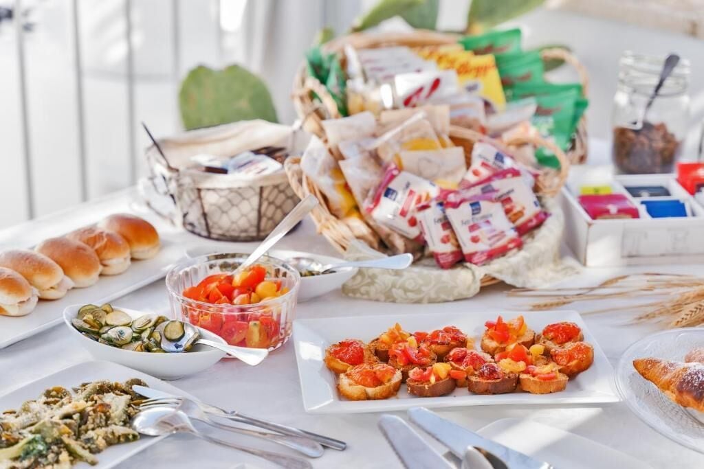 Ein Tisch mit verschiedenen Speisen, darunter Brot, Gebäck und einer Korb mit Snacks.
