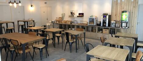 A modern cafe with wooden tables and chairs, a coffee machine, and a wooden partition wall.