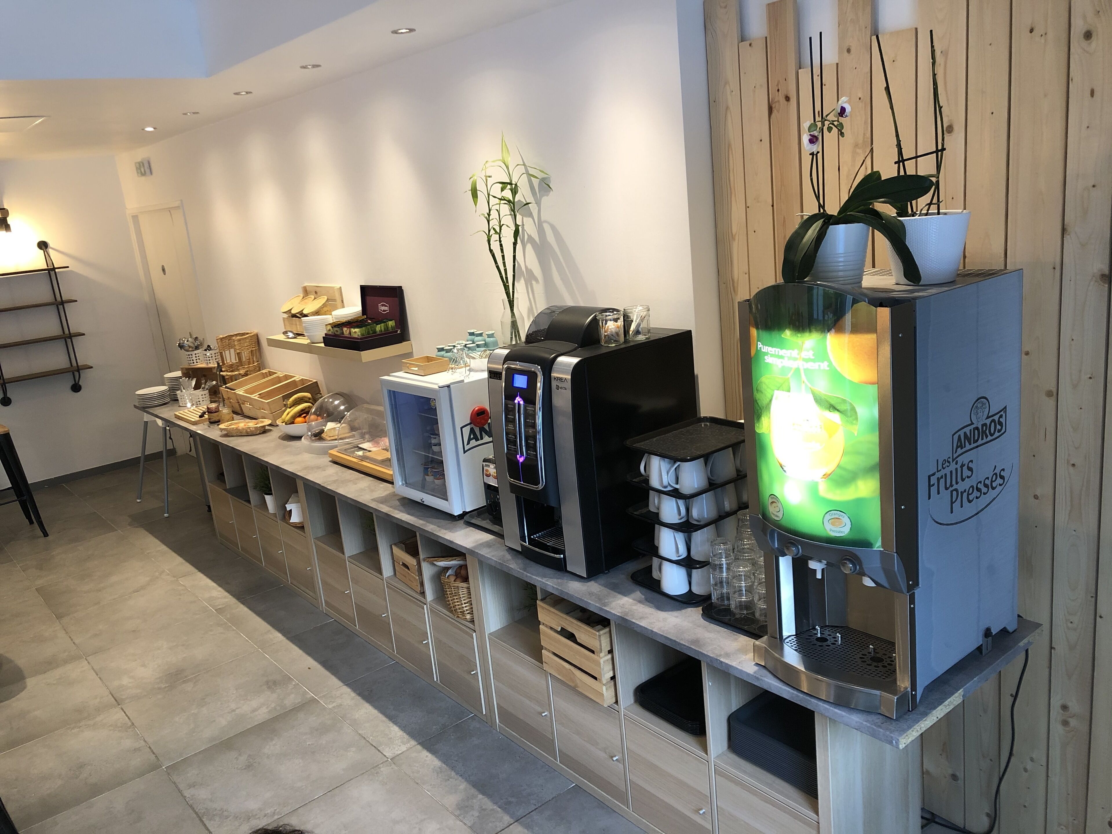 Una barra de desayuno con diversos alimentos y una máquina de café.