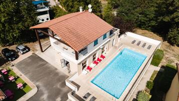Un bâtiment à deux étages doté d’une piscine, d’un espace extérieur aménagé et d’un patio couvert.