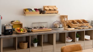 Uma bancada de cozinha com diversos alimentos, uma máquina de café e prateleiras de armazenamento.