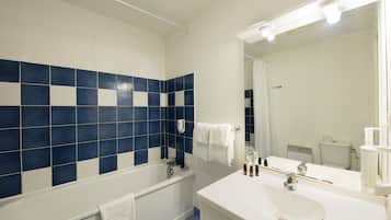 A bathroom with a bathtub, a sink, and a mirror.