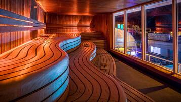 A modern interior with wooden curved benches and large windows.