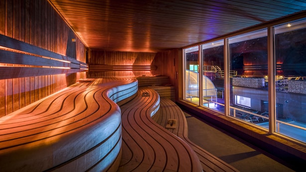 A modern interior with wooden paneling and a curved bench area. - Fletcher Wellness-Hotel Brabant-Mill (Mill)