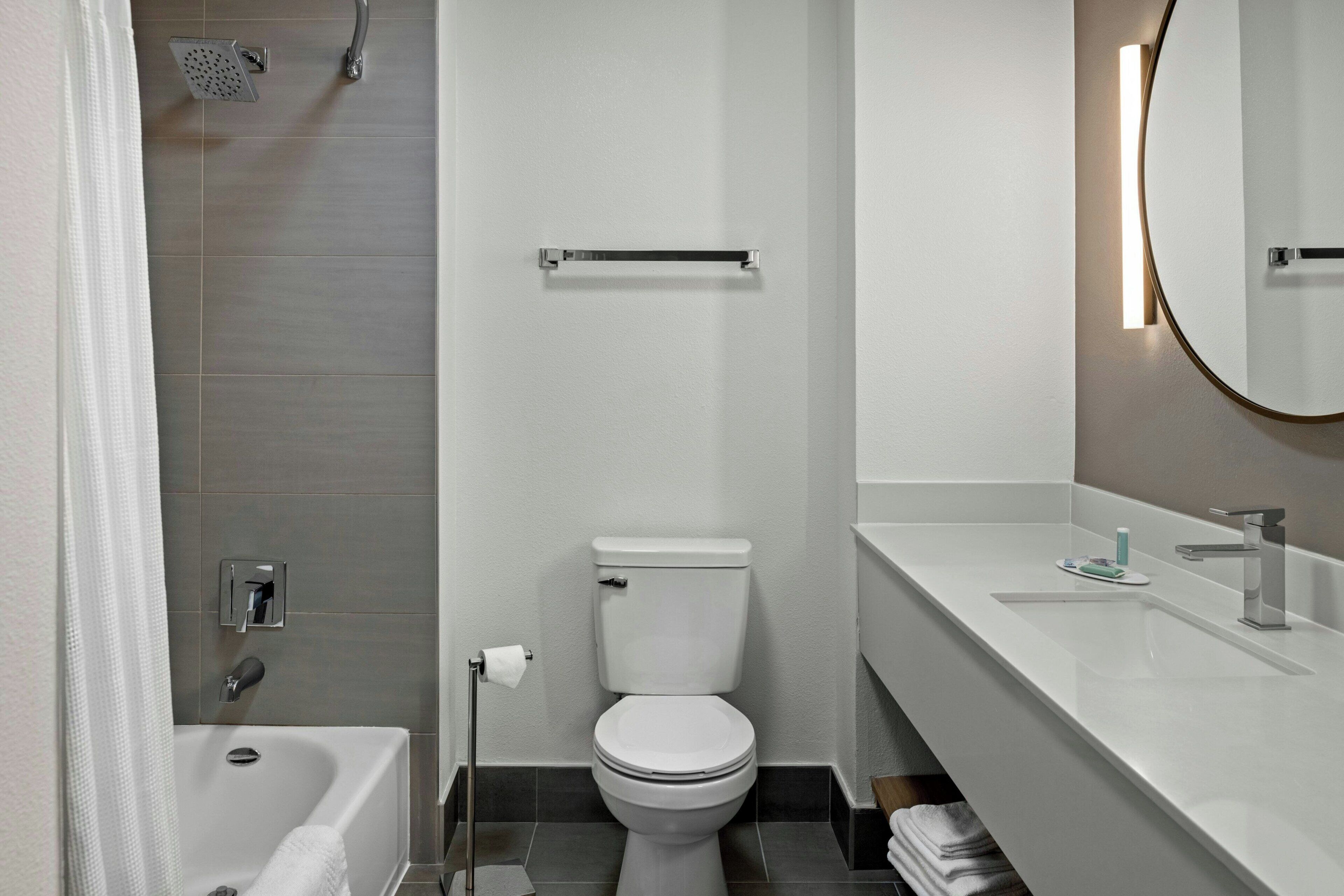 A modern bathroom with a bathtub, toilet, and sink.