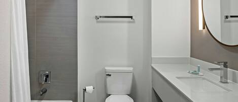 A modern bathroom with a bathtub, toilet, and sink.