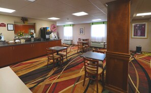 A hotel dining area with a buffet, multiple tables, chairs, and a patterned carpet. - Jefferson Inn Dandridge (Dandridge)